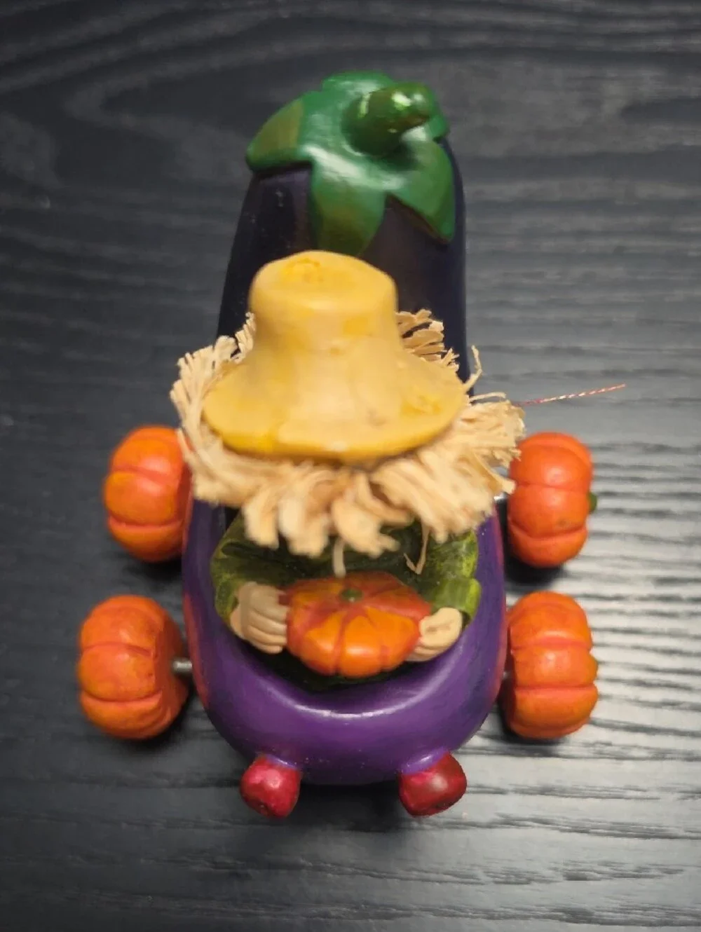 Autumn figurine of a scarecrow in a Eggplant cart